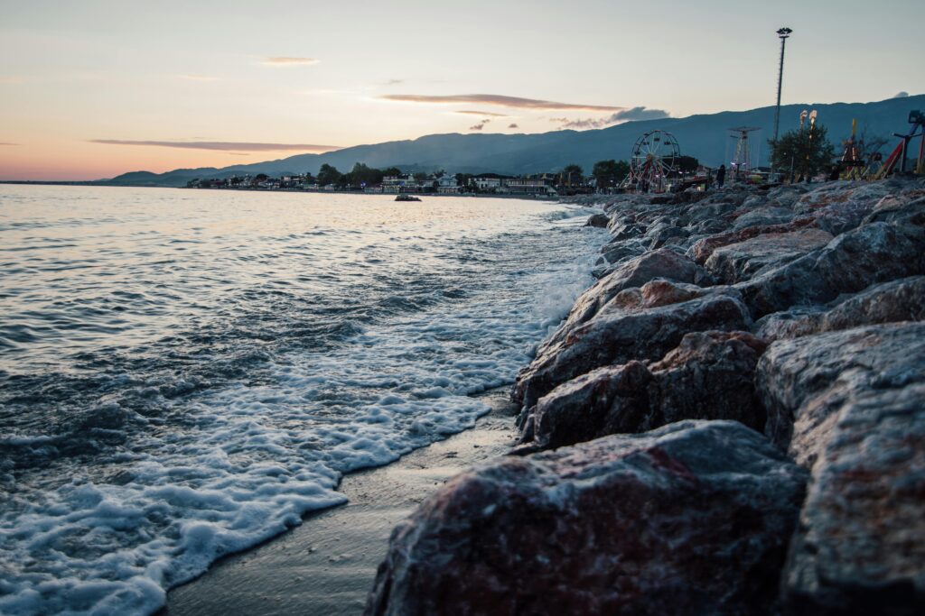 A serene coastal town by the sea with rocky shores at sunset, showcasing natural beauty and tranquility.