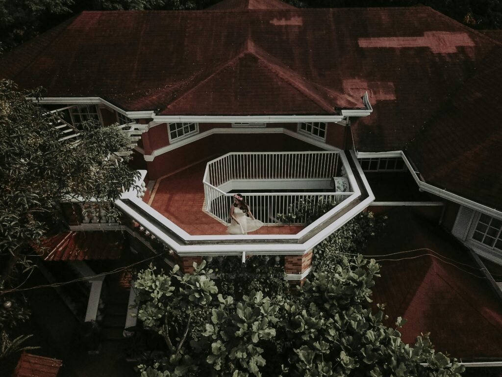 Aerial shot of a house with a balcony featuring elegant design and greenery.